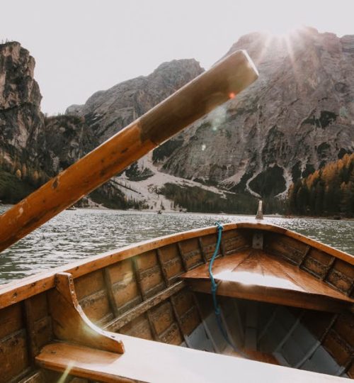 Wooden rowboat on a tranquil mountain lake with a stunning alpine view.